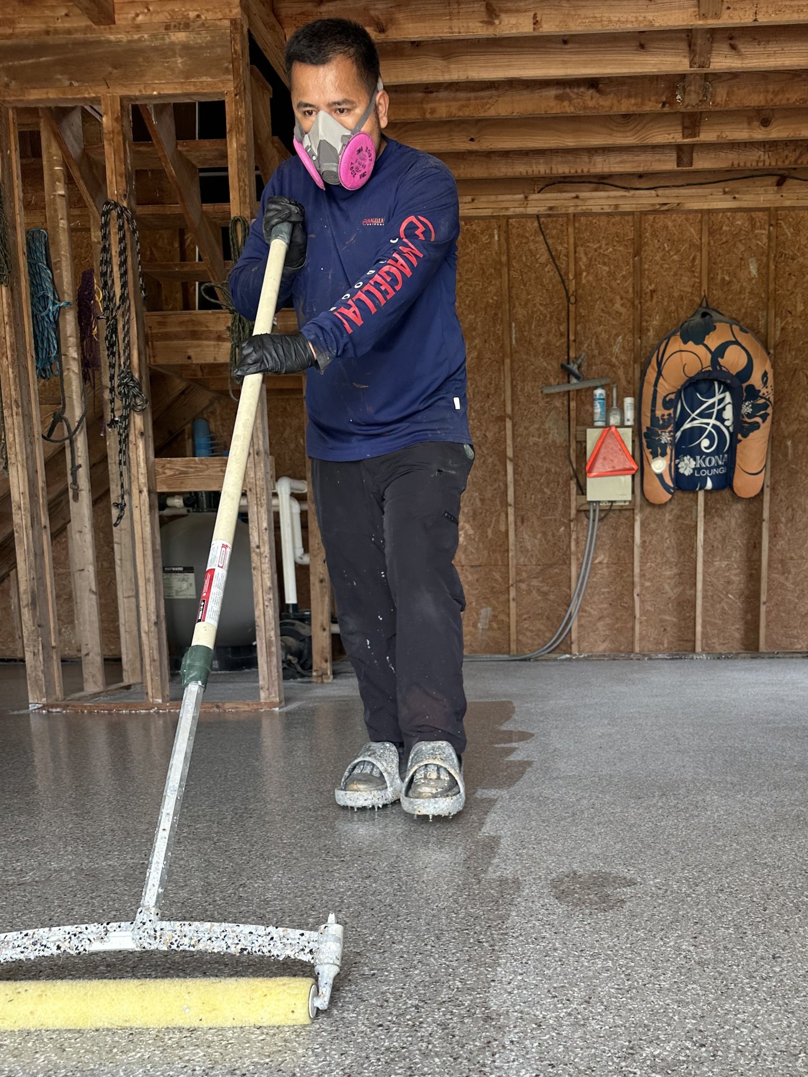Installer squeegeeing the polyaspartic topcoat across a barn floor